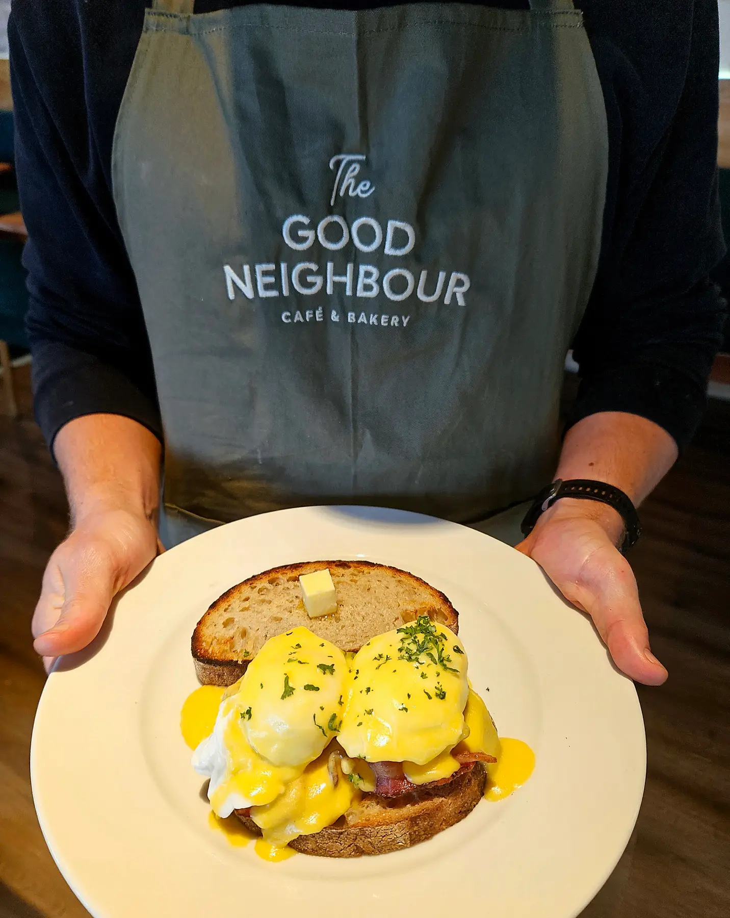 Staff serving eggs benedict at The Good Neighbour
